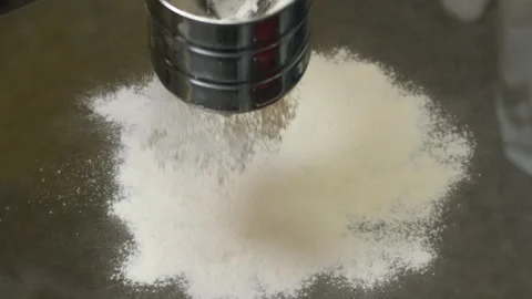 Flour is poured out onto the black surface of the table isolated on glass table Stock Footage 301436973