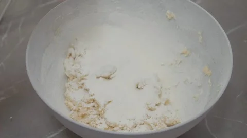 Flour pours into a bowl while making cookie dough for delicious treats Stock Footage 329281160