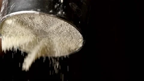 Flour pours from a sieve on a black background, macro Stock-Footage 140258252