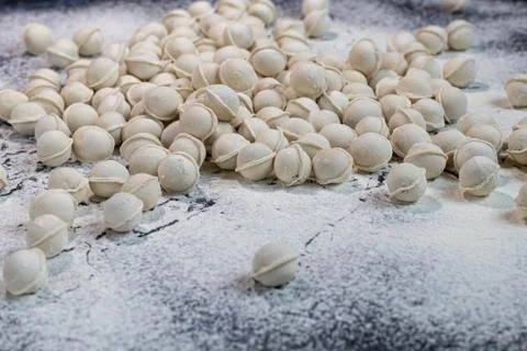 Flour pours onto the table. In order to make dough products, mini-dumplings a Фото