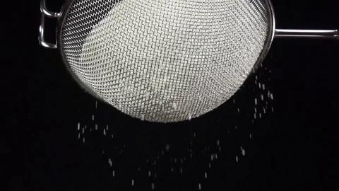 Flour sift through sieve on black background in slow motion Stock Footage 75486383