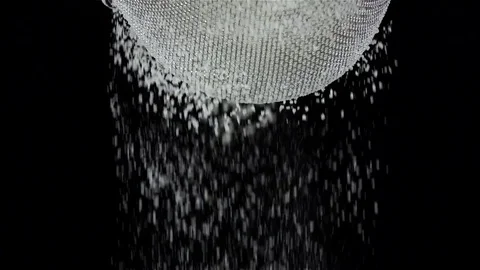 Flour sift through sieve on black background. Slow motion, closeup Stock Footage 75487318