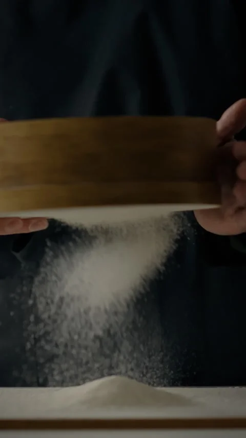 Flour sifting process in a pizzeria bakery by a woman during food preparatio Stock Footage 331582409