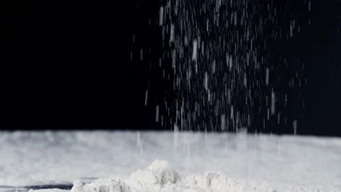 Flour is slowly falling on the black background. Stock Footage 140182422