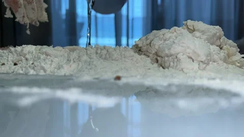 Flour on the table into which water is poured in slow motion Stock Footage 221201771