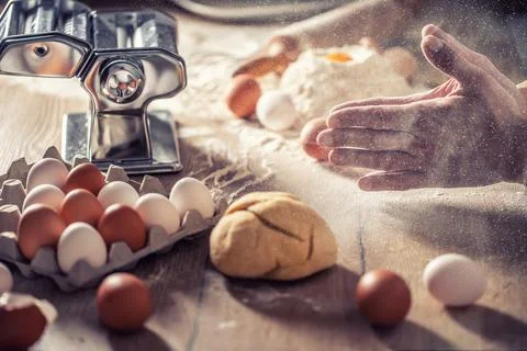 Floured hands clapping during fresh egg and flour dough preparation for a h.. 写真素材