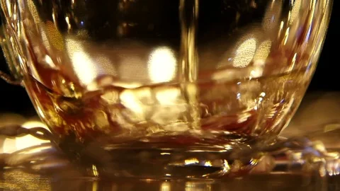 Flow of black tea being poured into cup. Slow motion Stock Footage