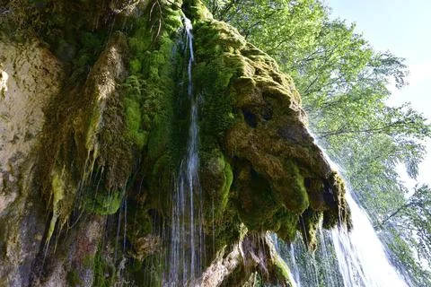The flow of clean and cold spring water along the plaster rock of the Plakun  Stock Photos
