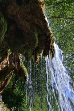 The flow of clean and cold spring water along the plaster rock of the Plakun  Stock Photos
