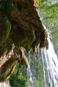 The flow of clean and cold spring water along the plaster rock of the Plakun  Stock Photos