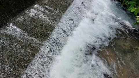 The flow of clear and swift river water in a dam Stock Photos