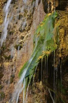 The flow of cold and clean spring water of the Plakun waterfall on the right  Stock Photos