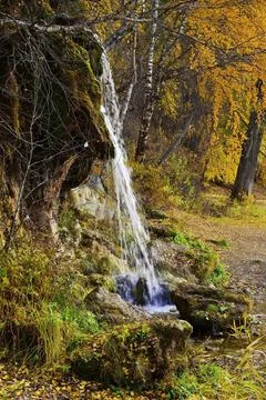 The flow of cold and clean spring water of the Plakun waterfall on the right  Stock Photos