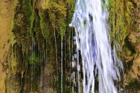 The flow of cold and clean spring water of the Plakun waterfall on the right  Stock Photos