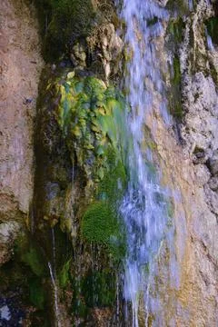 The flow of cold and clean spring water of the Plakun waterfall on the right  Stock Photos