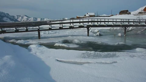 The flow of the freezing river. Rural winter landscape. A small river and a Stock Footage 130639498