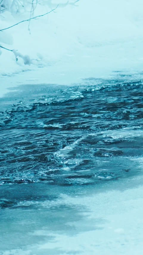 The flow of fresh icy water in a mountain river erodes the ice in winter. Vídeo Stock 344020497
