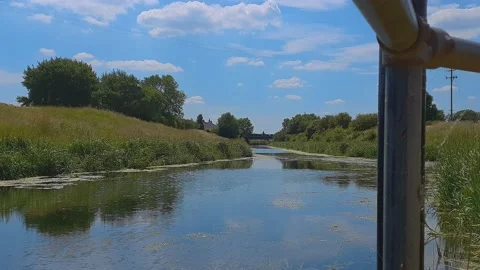 The flow if a canal viewed through reeds from the river bank Stockbeeldmateriaal 201586713