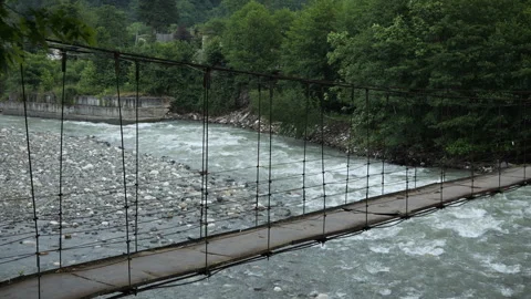 The flow of a mountain river and a bridge Stock Footage 333039572