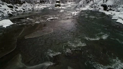 Flow of a mountain winter river on a cloudy day. Winter. Video stock 229170902