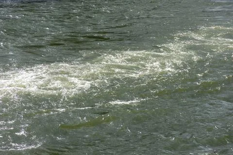 The flow of the river reflects the sun into its waters Stock Photos