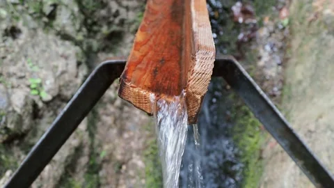 Flow of spring in wooden  gutter in mountains Stockbeeldmateriaal 138380533