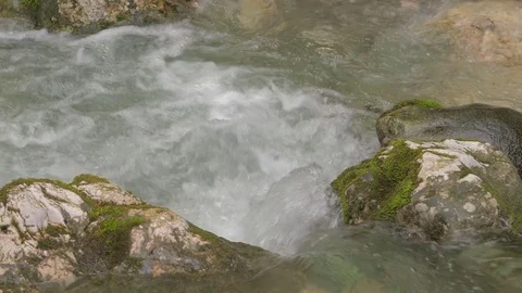 The flow of water flows between two stones overgrown with green moss in realtime 스톡 동영상 78047008