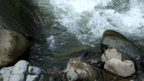The flow of water hits the rocks on the river bank Stock Footage 292841908