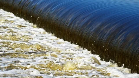 The flow of water from the outlet of an artificial dam Stock Footage 240984335