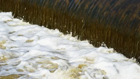 The flow of water from the outlet of an artificial dam Stock Footage 241650080