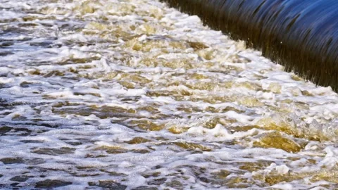 The flow of water from the outlet of an artificial dam Stock Footage 241657089