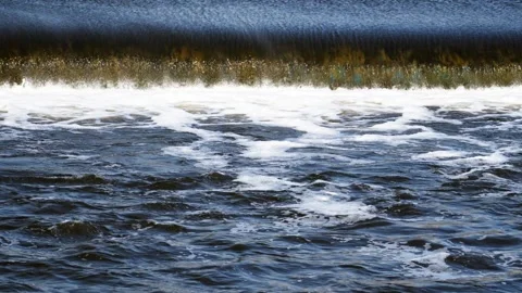 The flow of water from the outlet of an artificial dam Stock Footage 241658056