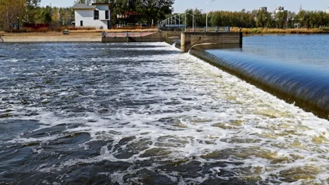 The flow of water from the outlet of an artificial dam Stock Footage 241658901