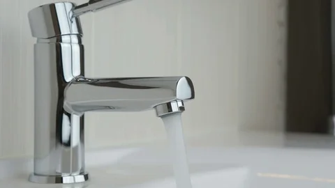 Flow of water pouring from chrome-plated faucet Stock-Footage 72498138