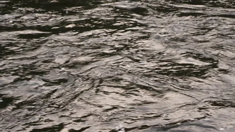 Flow of water into rivers. The surface of the river. Close up. Background Stock Footage 140345263