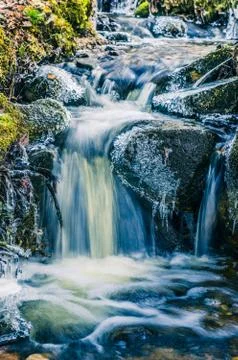 Flow of water in the spring of icicles and ice Stock Photos