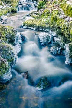Flow of water in the spring of icicles and ice Stock Photos