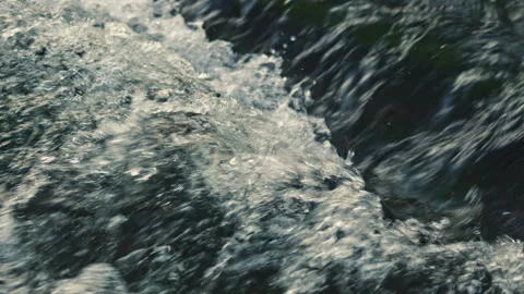 Flow of water from a spring. Strong current of river water. Flow of water over Stock Footage 331375659