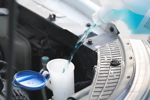 Flow windshield fluid into the windshield washer reservoir Stock Photos