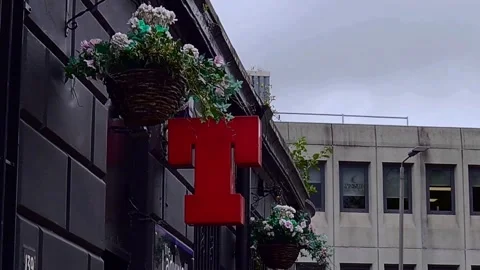 Flower baskets blowing in the wind outside a bar Stock Footage 200213107