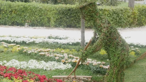 A flower bed with a peasant built with branches and flowers Stock Footage 88989114