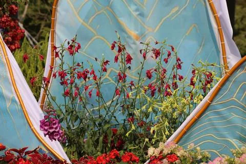 A flower bed in the shape of an arch with many different flowers. in front,.. Stock Photos