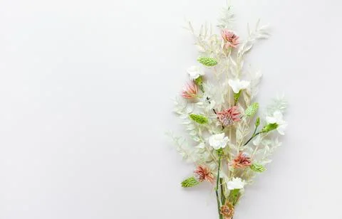 Flower composition made of dried light-green leaves of ruscus and white flowe Stock Photos