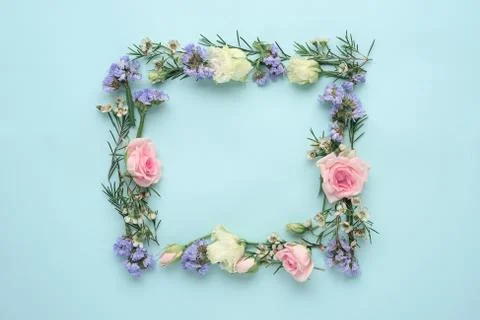 Flower frame on blue background, composition of roses, limonium, eustoma, top Stock Photos