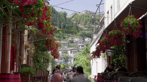 Flower-lined street in the Old Bazaar of Gjirokastër historic city in southern Stock Footage 345367641