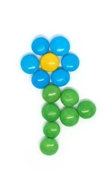 Flower of many colored small round candies isolated on a white background Stock Photos