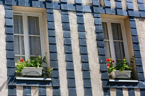 Flower pot placed at the window of old brittany house Stock Photos