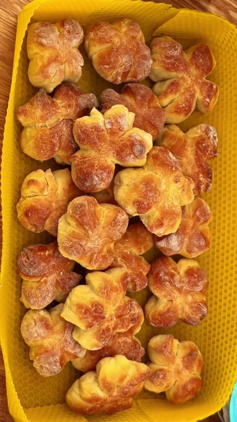 Flower-Shaped Bread Rolls Arranged in Yellow Tray on Wooden Table, Close Up Stock Footage 337386051