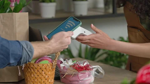In a flower shop, the customer pays using a contactless terminal using NFC Video stock 149942665