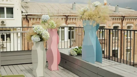 Flower vases filled with vibrant hydrangeas adorning a modern balcony setting Stock Footage 318067000